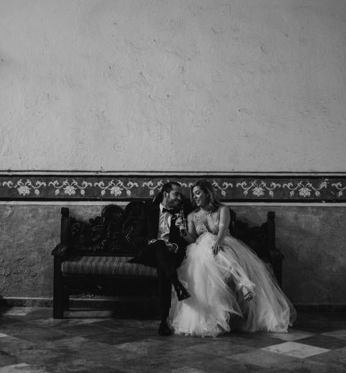 Documentary Wedding Photography of a couple in formal attire sharing intimate moment on vintage bench.