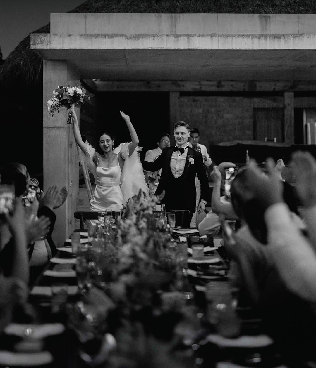 Bride and groom entering beach reception. Documentary photography.