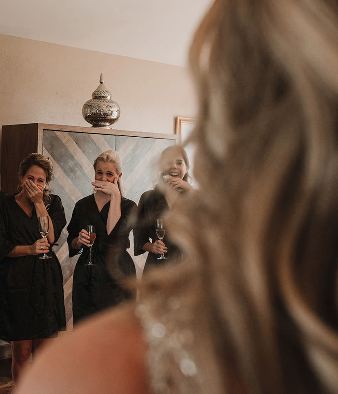 Bridesmaids reacting to bride reveal. Documentary photography.