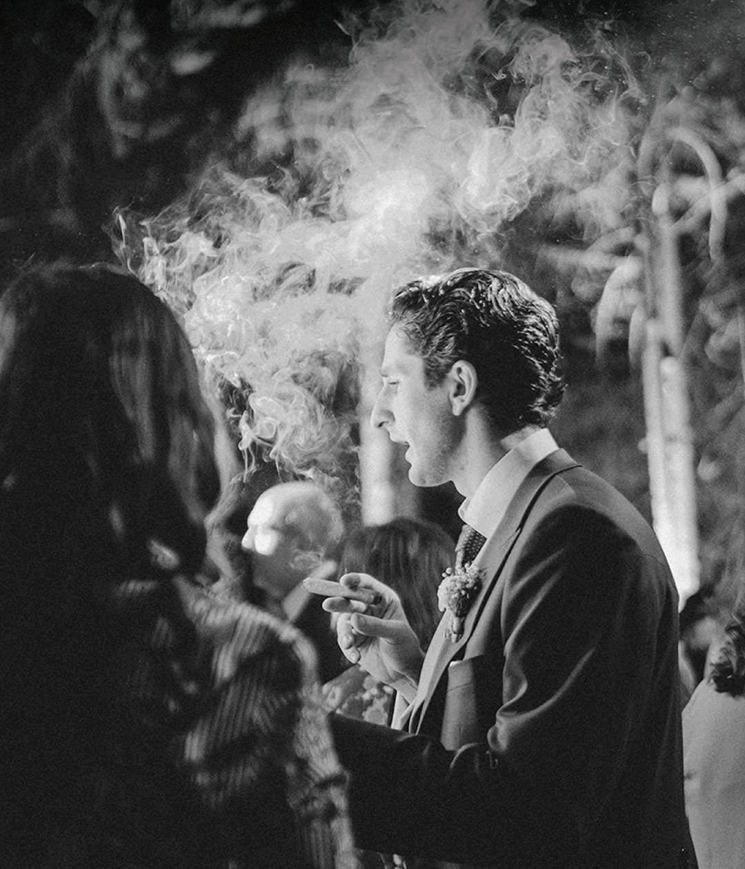 Groom with cigar in a cloud of smoke. Documentary photography.