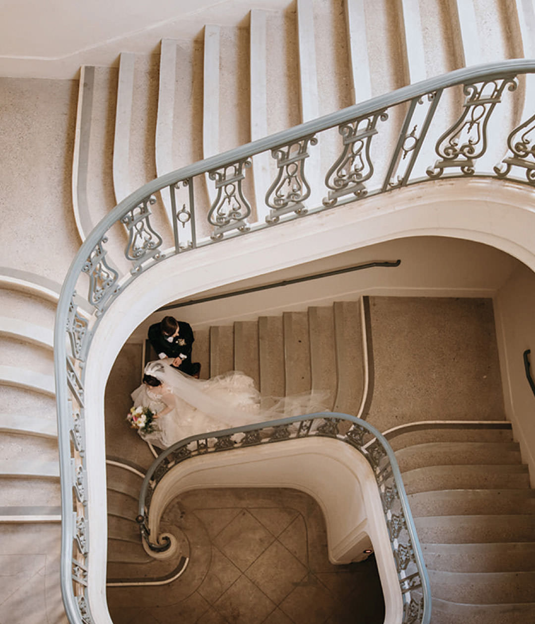 Couple walking down elegant staircase. Documentary photography.