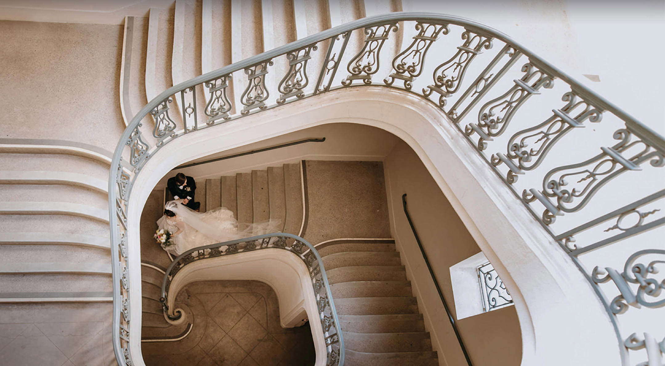 Breathless Weddings Bride and groom descending a spiral staircase.